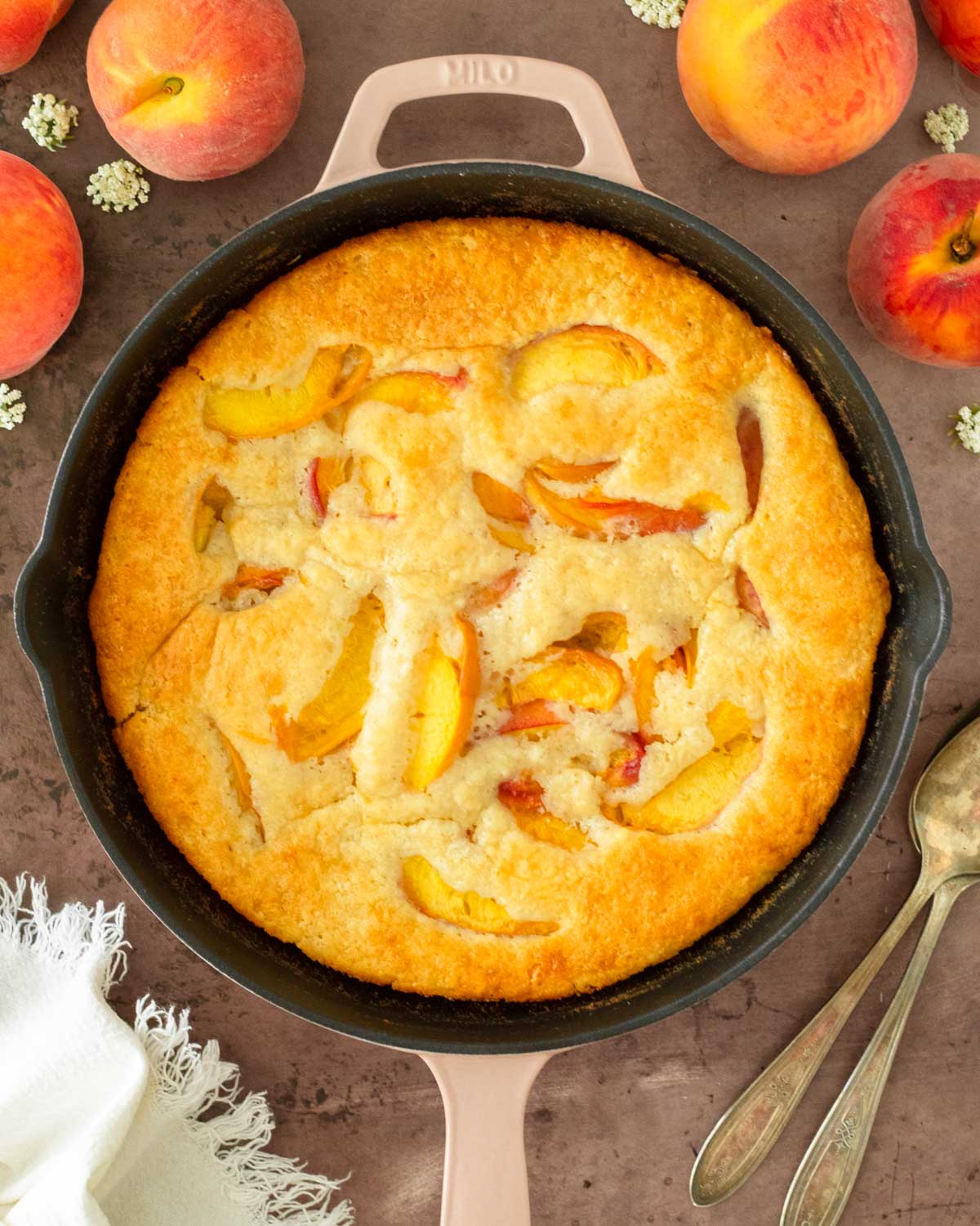 This peach cobbler is an easy summer dessert recipe that combines fresh-picked peaches with a creamy batter to make a delicious one-skillet dessert.