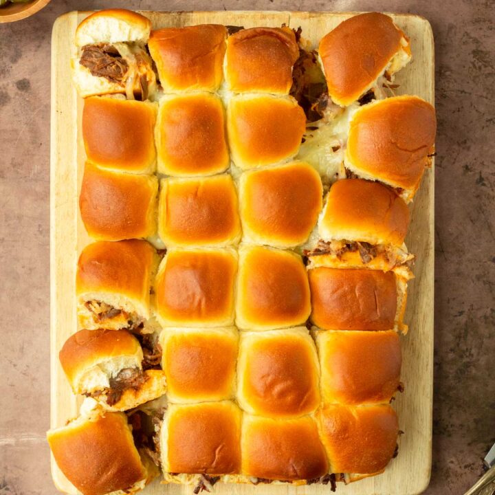 These BBQ pulled beef sliders are an easy and delicious Hawaiian roll pull-apart sandwich made with BBQ pulled beef and mozzarella cheese layered inside perfectly baked Hawaiian rolls for an easy dinner, delicious appetizer and the perfect recipe to serve a crowd.