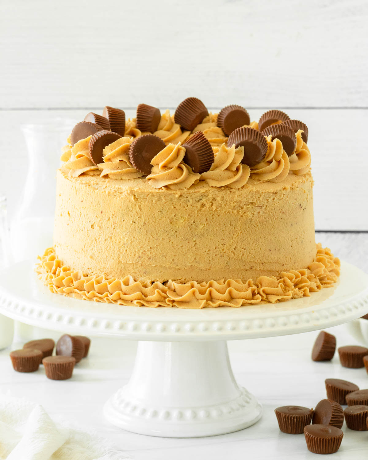 This chocolate cake peanut butter cup cake is a deliciously decadent chocolate cake topped with a creamy peanut butter frosting and decorated with peanut butter cups for a delicious chocolate peanut butter dessert.