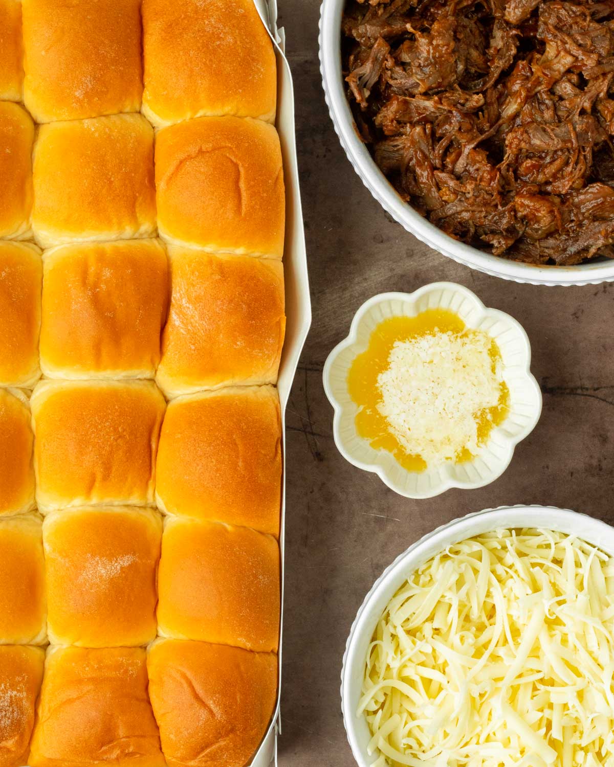 These BBQ pulled beef sliders are an easy and delicious Hawaiian roll pull-apart sandwich made with BBQ pulled beef and mozzarella cheese layered inside perfectly baked Hawaiian rolls for an easy dinner, delicious appetizer and the perfect recipe to serve a crowd.