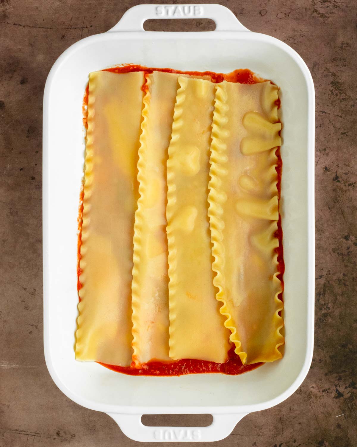 Step 1. Pour a layer of meat sauce over the bottom of the dish and place a layer of noodles on top