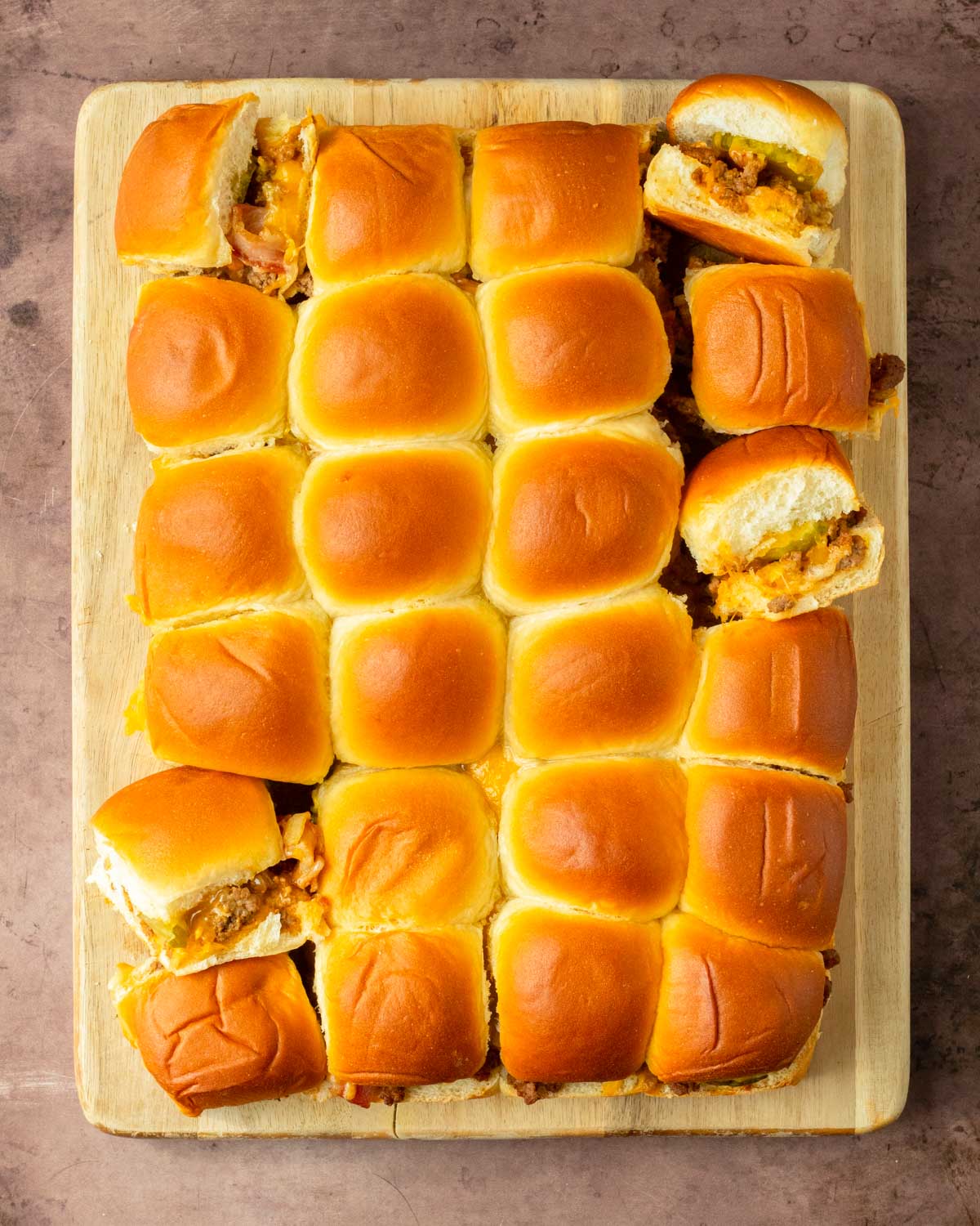 These Bacon Cheeseburger Sliders are an easy and delicious Hawaiian roll pull-apart sandwich recipe made with ground beef, bacon and cheese layered inside perfectly baked Hawaiian rolls for an easy dinner, delicious appetizer and the perfect recipe to serve a crowd.