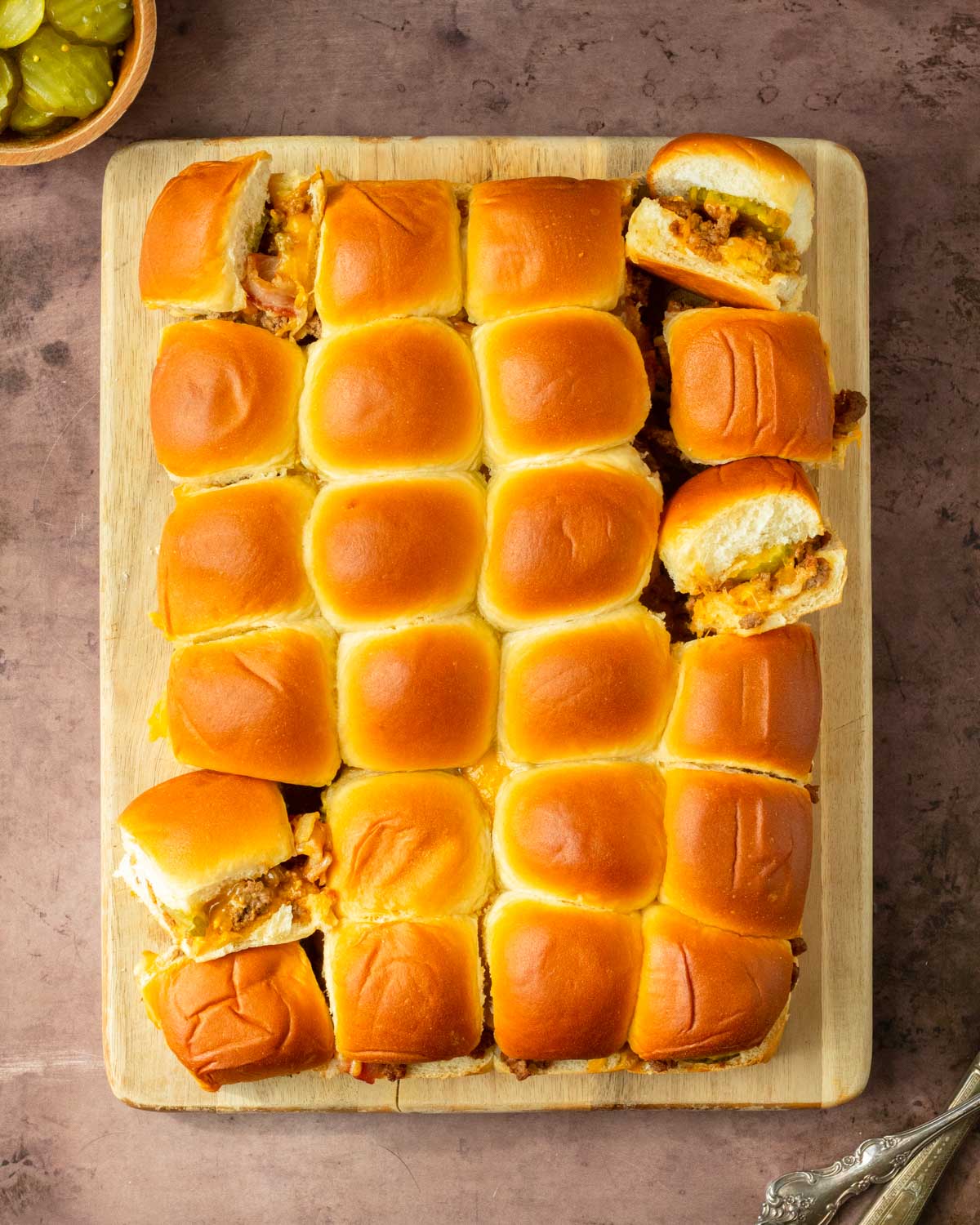 These Bacon Cheeseburger Sliders are an easy and delicious Hawaiian roll pull-apart sandwich recipe made with ground beef, bacon and cheese layered inside perfectly baked Hawaiian rolls for an easy dinner, delicious appetizer and the perfect recipe to serve a crowd.