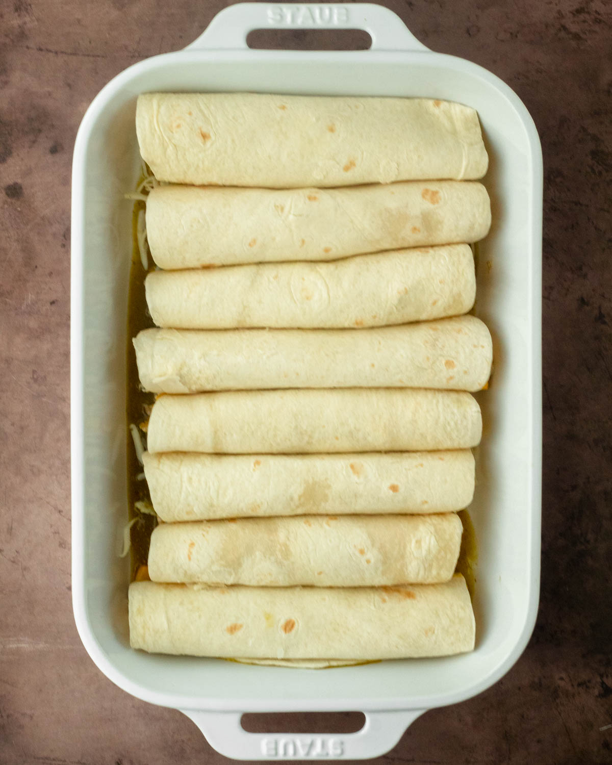 Step 1. Fill the tortillas with the chicken mixture and cheese then roll up and place in the baking pan