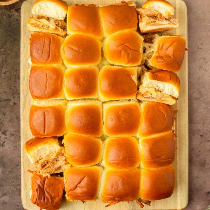 These BBQ pulled pork sliders are an easy and delicious Hawaiian roll pull-apart sandwich recipe made with BBQ pulled pork and Pepper Jack cheese layered inside perfectly baked Hawaiian rolls for an easy dinner, delicious appetizer and the perfect recipe to serve a crowd.