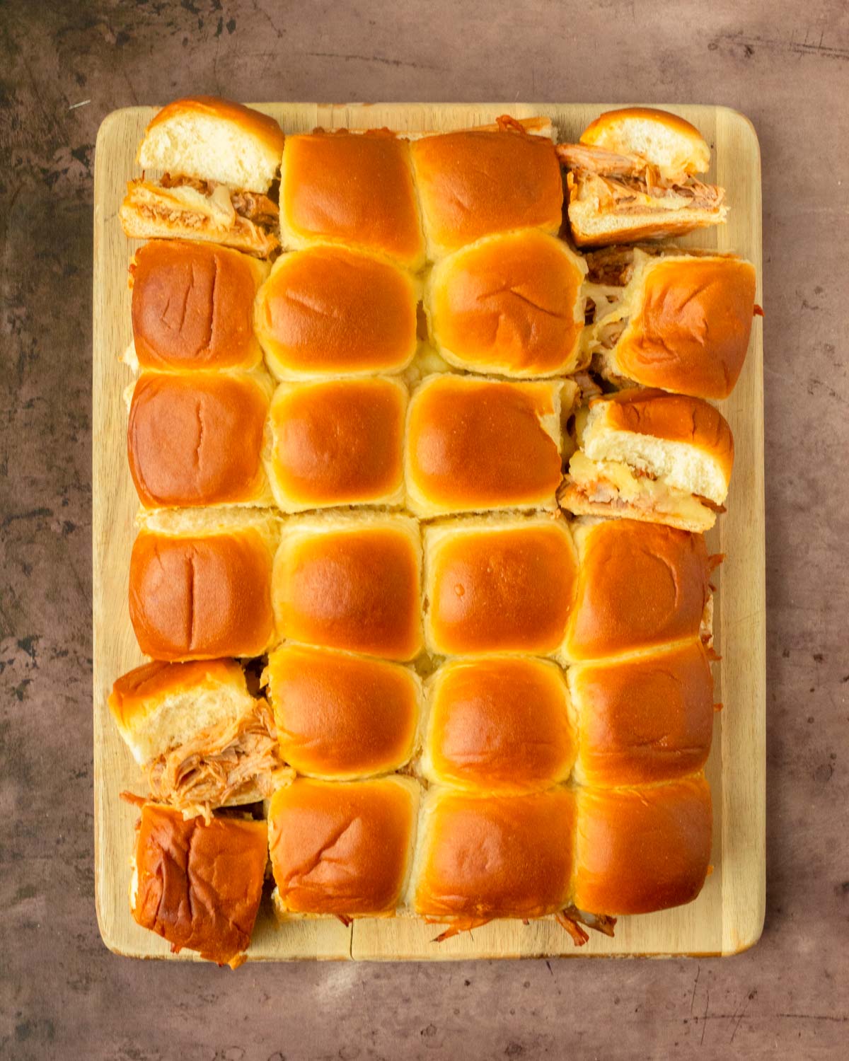 These BBQ pulled pork sliders are an easy and delicious Hawaiian roll pull-apart sandwich recipe made with BBQ pulled pork and Pepper Jack cheese layered inside perfectly baked Hawaiian rolls for an easy dinner, delicious appetizer and the perfect recipe to serve a crowd.