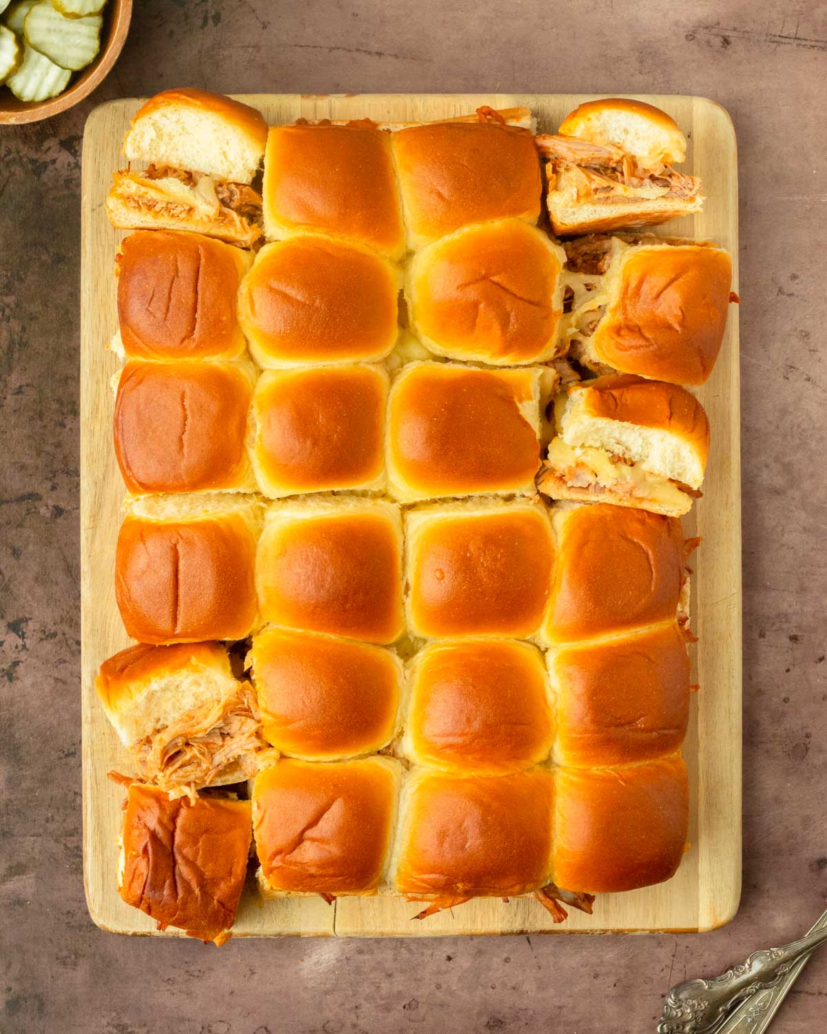 These BBQ pulled pork sliders are an easy and delicious Hawaiian roll pull-apart sandwich recipe made with BBQ pulled pork and Pepper Jack cheese layered inside perfectly baked Hawaiian rolls for an easy dinner, delicious appetizer and the perfect recipe to serve a crowd.