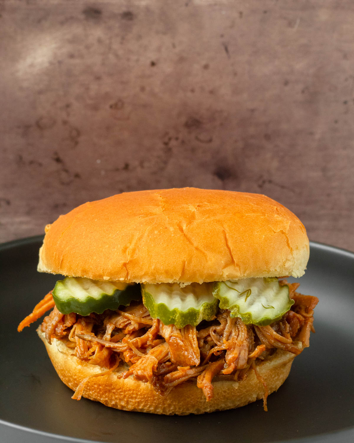 This crockpot BBQ pulled pork recipe is a great slower cooker pork recipe perfect for easy weeknight dinners and delicious summer cookouts.