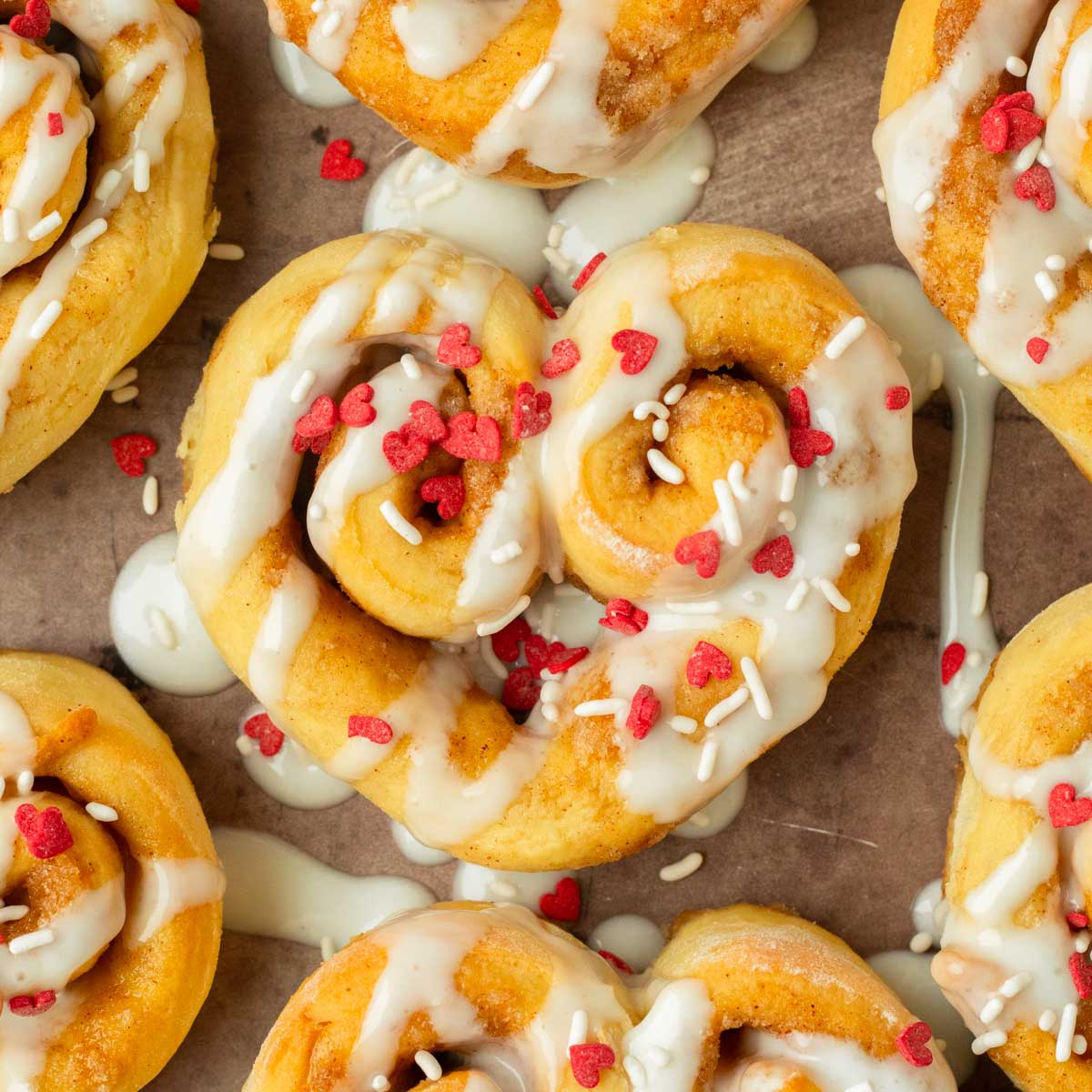 These heart shaped cinnamon rolls are the perfect easy and delicious Valentine's day treat. Made with our classic cinnamon roll recipe and shaped into hearts, this dessert is an easy to make crowd-pleaser recipe!