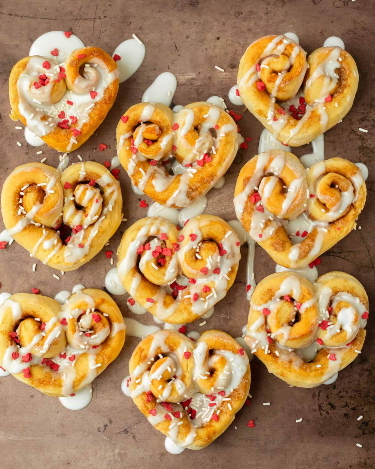 These heart shaped cinnamon rolls are the perfect easy and delicious Valentine's day treat. Made with our classic cinnamon roll recipe and shaped into hearts, this dessert is an easy to make crowd-pleaser recipe!