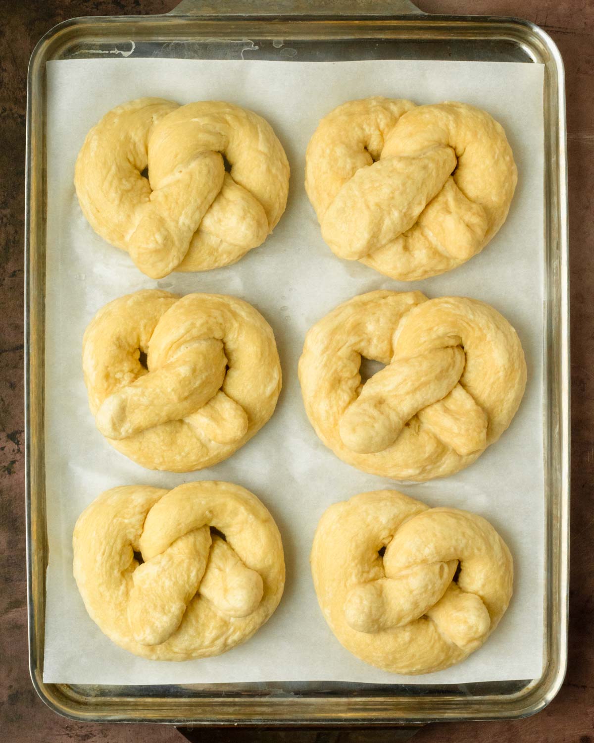 Step 3. Shape the pretzels, boil in baking soda and water then place on a sheet pan.